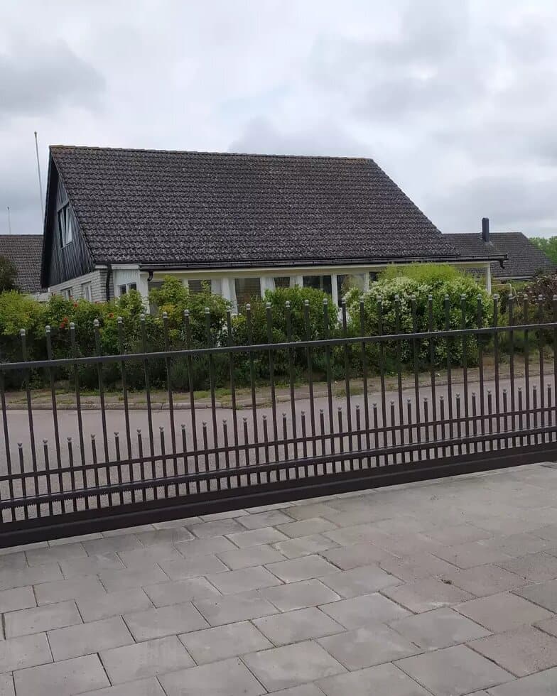 Villa med ny stenlagd uppfart och svart smidesgrind